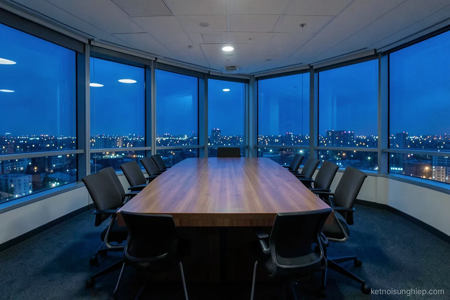 Wide shot of an empty boardroom at night, long table with neatly pushed-in chairs, city lights through floor-to-ceiling windows, cool blue tones
